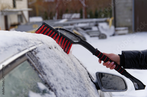 Odśnieżanie auta, atak zimy, zimowa aura i śnieżyca.
