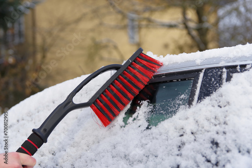 Odśnieżanie auta, atak zimy, zimowa aura i śnieżyca. 