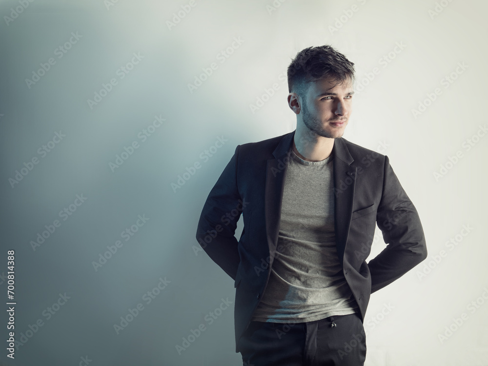 Naklejka premium Photo of a man posing in front of a white brick wall