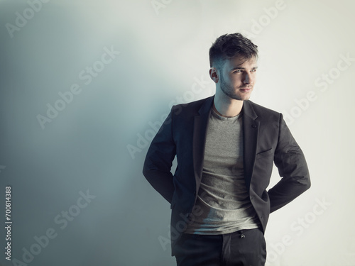 Photo of a man posing in front of a white brick wall