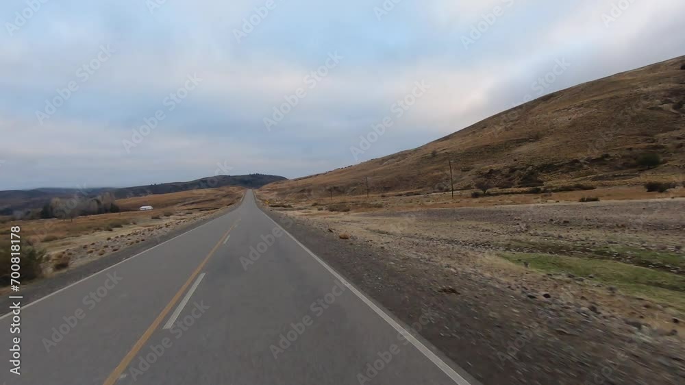 Traveling along the country route at dawn. View of the yellow field and hills under a beautiful sky. Traveling along the country route at dawn. View of the yellow field and hills under a beautiful sky.