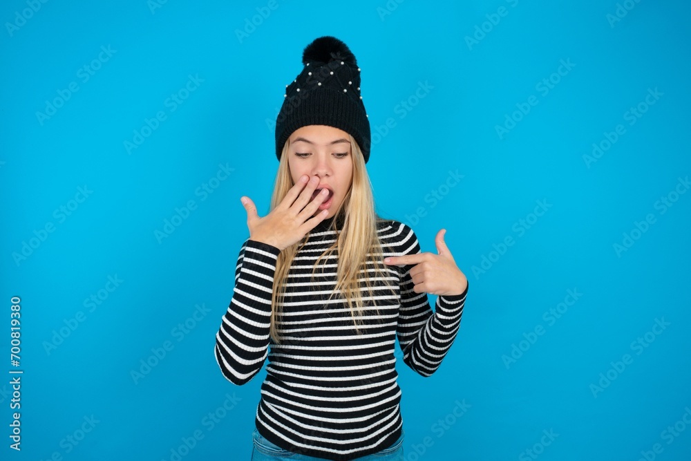 Shocked Teen caucasian girl wearing striped sweater and woolly hat look ...