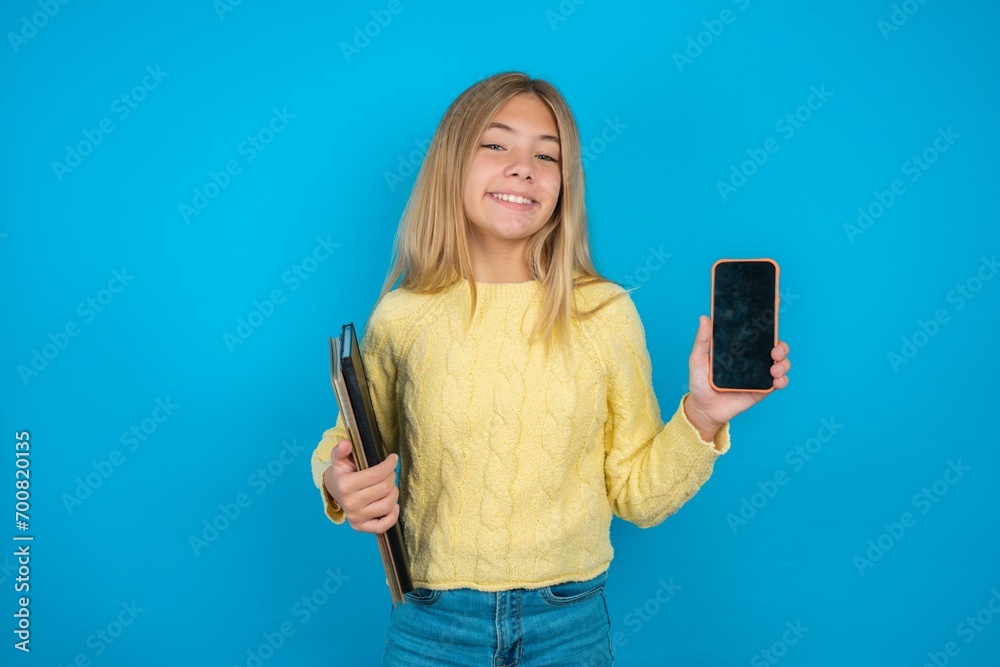 Beautiful kid girl wearing yellow sweater holding notebook hold hand modern technology use touch face palm astonished impressed scream wow omg unbelievable unexpected Beautiful kid girl wearing yellow sweater holding notebook hold hand modern technology use touch face palm astonished impressed scream wow omg unbelievable unexpected