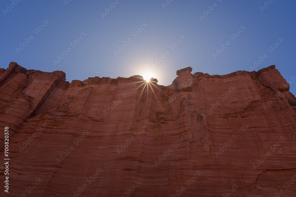 Naklejka premium Muro de piedra color rojo con sol con forma de estrella - Parque Nacional Talampaya - La Rioja - Argentina