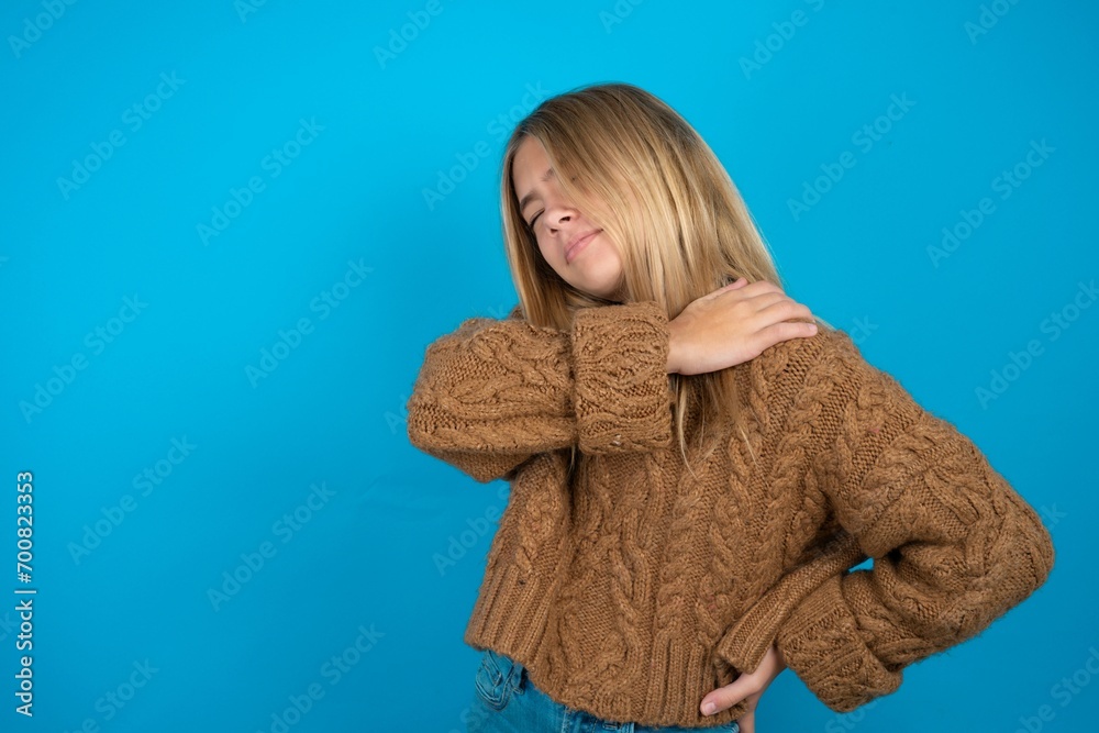 beautiful caucasian teen girl wearing brown sweater got back pain