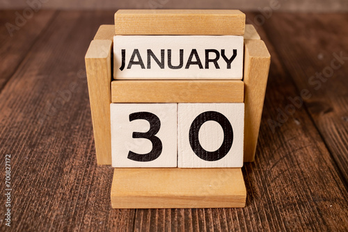Cube shape calendar for January 30 on wooden surface with empty space for text. photo