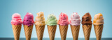 A delightful variety of colorful ice cream cones stand in a row against a soft blue backdrop, offering a tempting array of flavors.