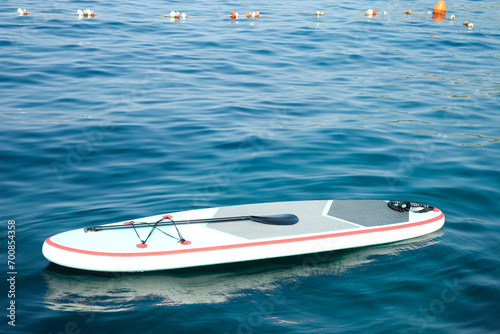One SUP board with paddle on water in sea