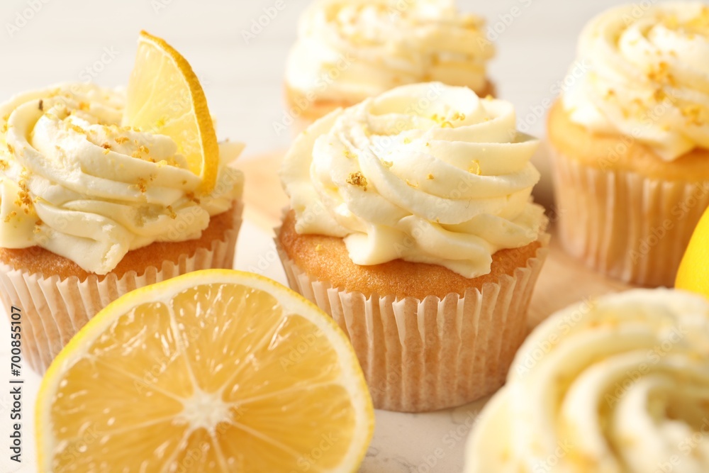 Tasty cupcakes with cream and lemon zest on board, closeup Tasty cupcakes with cream and lemon zest on board, closeup