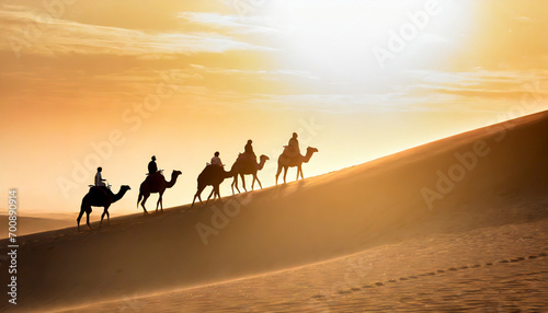 Camel caravan in the Sahara desert at sunset.
