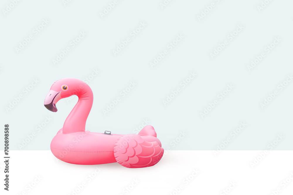 Pink pool plastic inflatable flamingo with light blue background - obrazy, fototapety, plakaty 