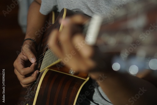 Close-up man playing acoustic guitar