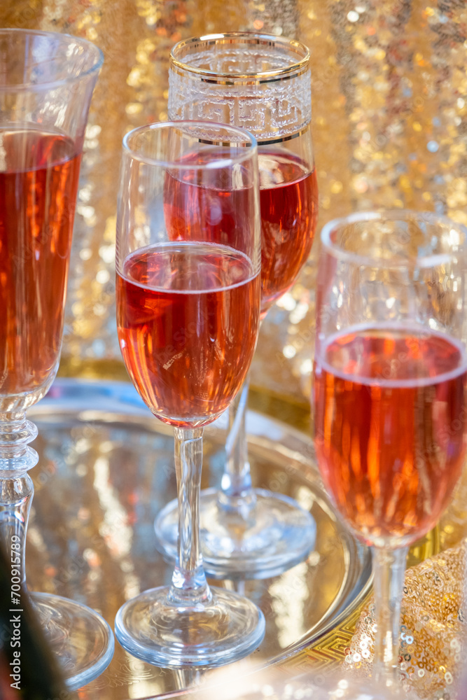 glasses of rose champagne on sparkling golden cloth glasses of rose champagne on sparkling golden cloth