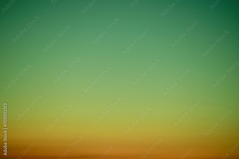 Sunset sky gradient from red to green, copy space. Clear sunset sky with the bright light of the setting sun