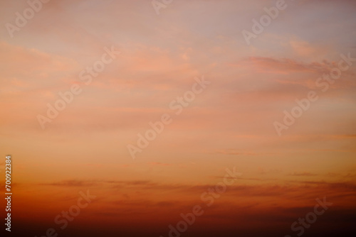 Evening clouds in the sunset sky in the light of the rays of the setting sun