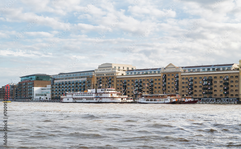 Firmengebäude und ein Segelschiff am Themseufer