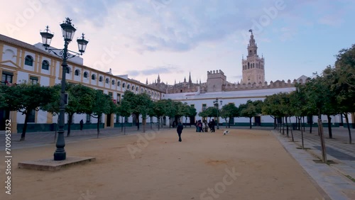 View of the Patio de Banderas courtyard in Seville, Spain. Sspacious square with orange trees, surrounded by historic buildings, offering views of Giralda tower. photo