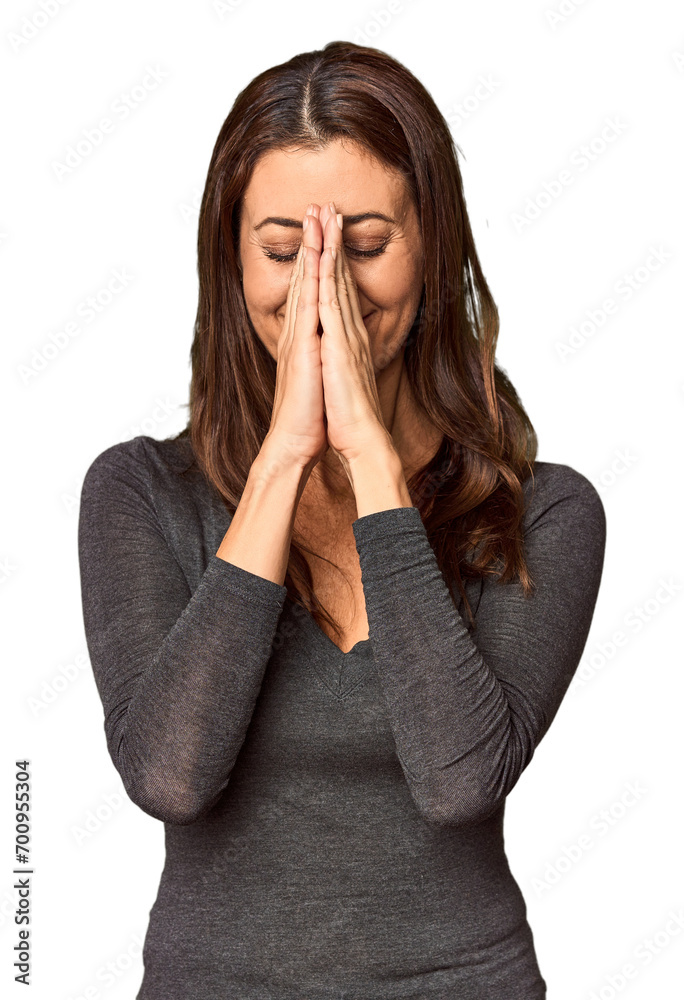 Elegant middle-aged Caucasian woman in studio setting holding hands in pray near mouth, feels confident. Elegant middle-aged Caucasian woman in studio setting holding hands in pray near mouth, feels confident.