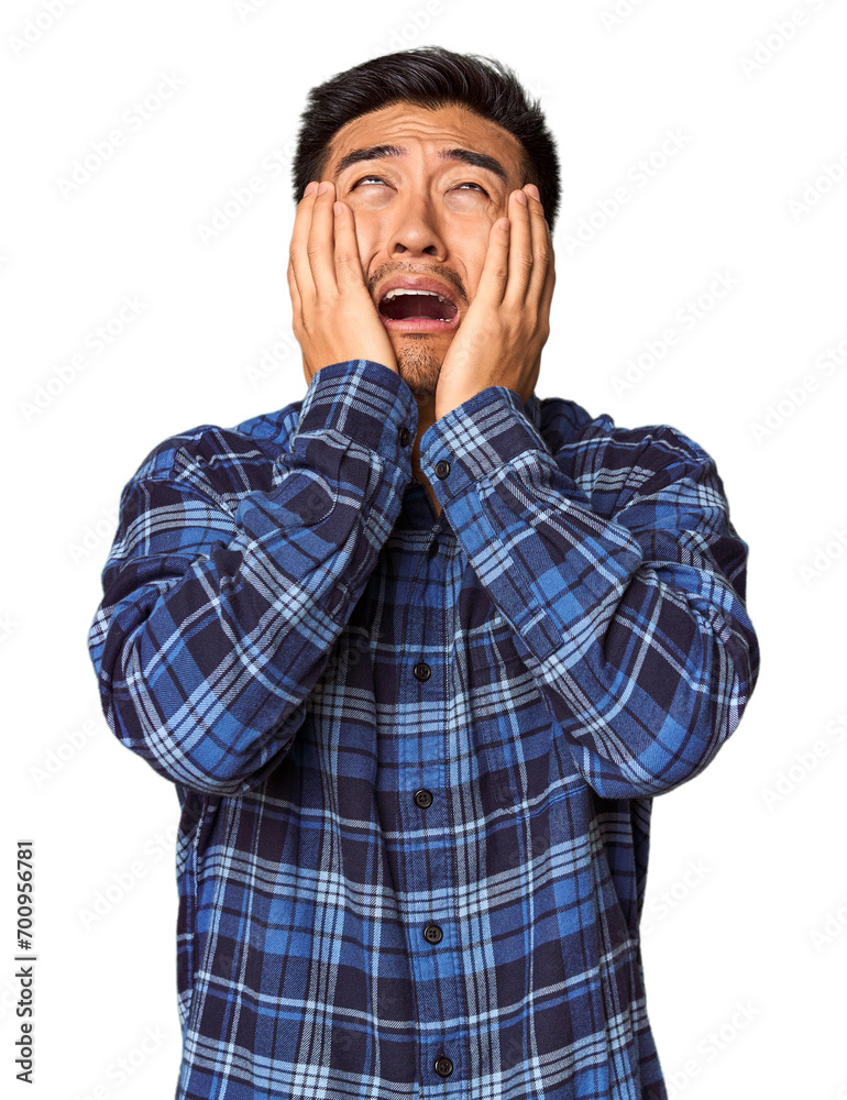 Young Chinese man in studio background whining and crying disconsolately. Young Chinese man in studio background whining and crying disconsolately.