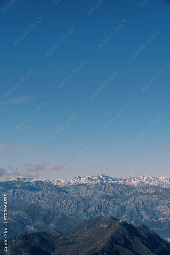 Mountain range above the Bay of Kotor against the blue sky in winter. Montenegro