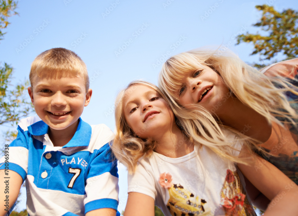 Fototapeta premium Happy children, portrait and playing at park for fun day, holiday or weekend together in nature. Face of young kids or siblings smile for outdoor summer break, bonding or youth on outdoor vacation