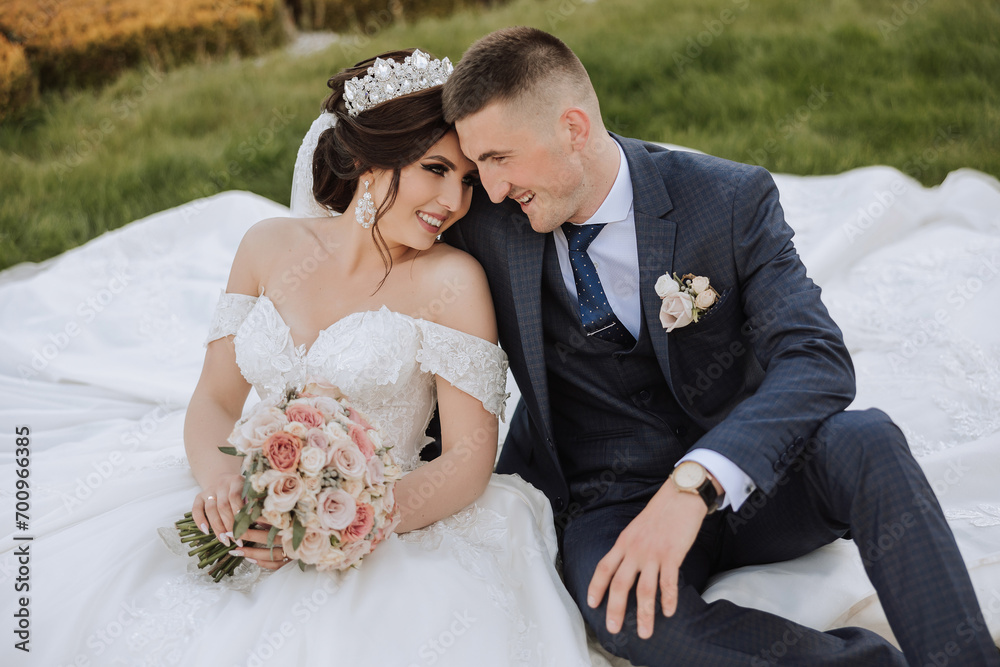 Wedding. Love and couple in garden for wedding. Celebration of ceremony and commitment. Save the date. Trust. The bride and groom embrace. The groom embraces the bride under a spring flowering tree. Wedding. Love and couple in garden for wedding. Celebration of ceremony and commitment. Save the date. Trust. The bride and groom embrace. The groom embraces the bride under a spring flowering tree.