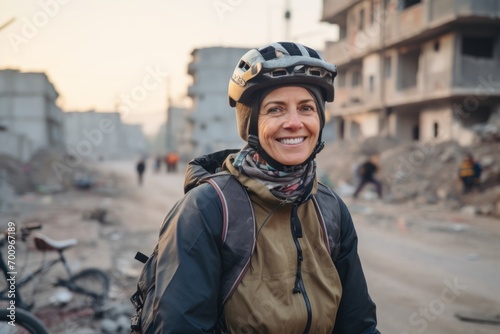 Portrait of a woman with a helmet on the background of the destroyed building. © Nerea
