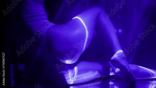 sexy ass of beautiful slender woman in darkness, purple laser rays illuminating female body photo