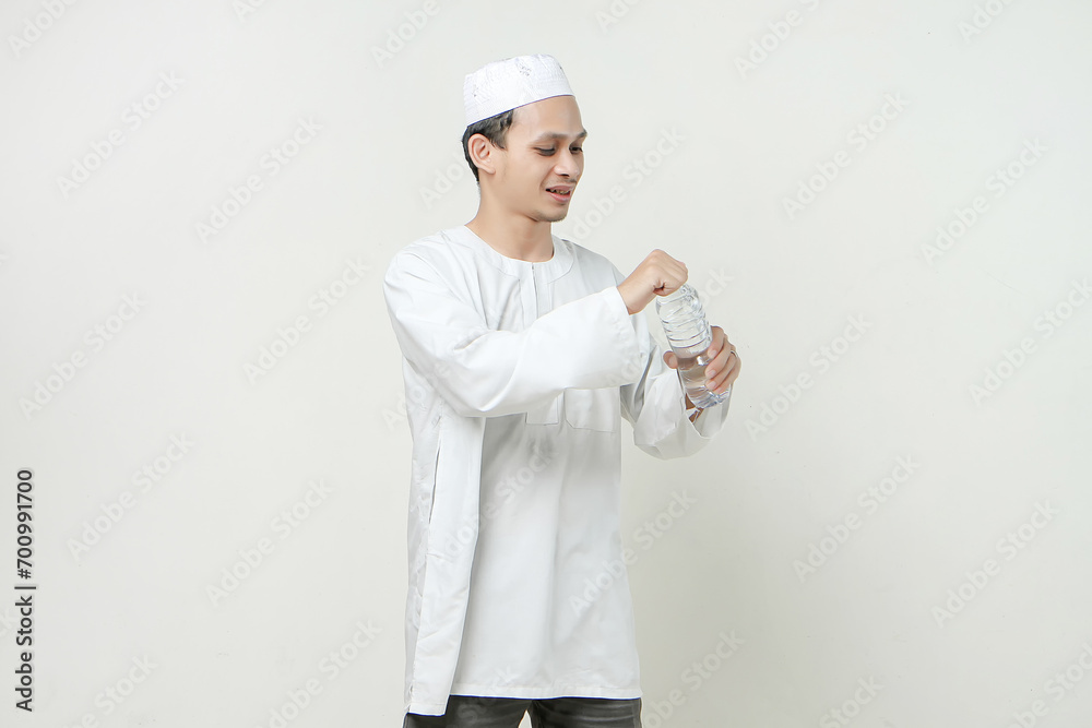asian muslim man opening water bottle. People religious Islam lifestyle concept. celebration Ramadan and ied Mubarak. on isolated background. asian muslim man opening water bottle. People religious Islam lifestyle concept. celebration Ramadan and ied Mubarak. on isolated background.