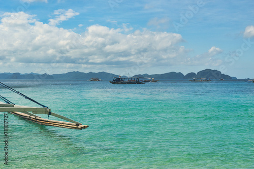 PALAWAN, PHILIPPINES - DECEMBER 21, 2023: Local traditional outrigger tour boat with tropical islands in El Nido on Palawan Island in the Philippines. 6 million tourists visited Philippines in 2016.