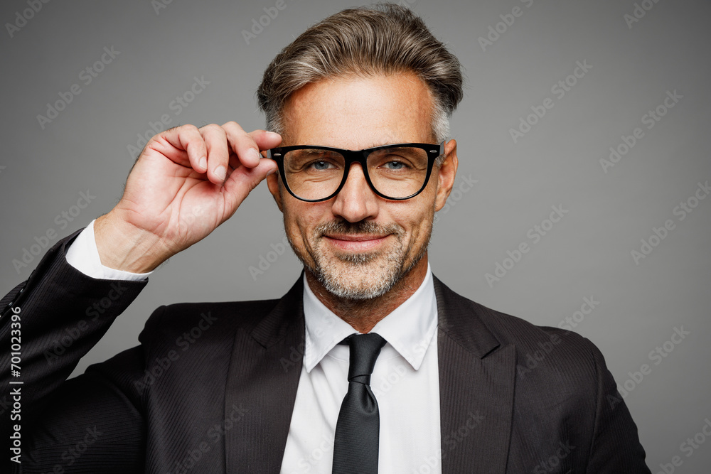 Close up adult successful employee business man corporate lawyer he wear classic formal black suit shirt tie work in office touch glasses look camera isolated on plain grey background studio portrait. Close up adult successful employee business man corporate lawyer he wear classic formal black suit shirt tie work in office touch glasses look camera isolated on plain grey background studio portrait.