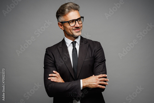 Adult happy successful employee business man corporate lawyer he wear classic formal black suit shirt tie work in office hold hands crossed folded look aside isolated on plain grey background studio.