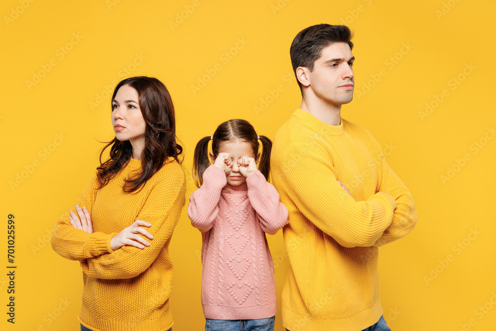 Young strict serious sad parents mom dad with child kid girl 7-8 years old wear pink knitted sweater casual clothes cover eyes with hands cry isolated on plain yellow background. Family day concept. Young strict serious sad parents mom dad with child kid girl 7-8 years old wear pink knitted sweater casual clothes cover eyes with hands cry isolated on plain yellow background. Family day concept.