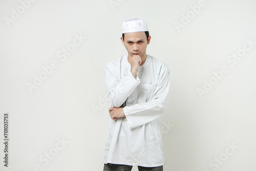 Asian Muslim touching his chin with his hand on isolated background. People religious Islamic lifestyle concept