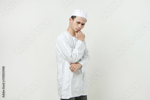 Asian Muslim touching his chin with his hand on isolated background. People religious Islamic lifestyle concept