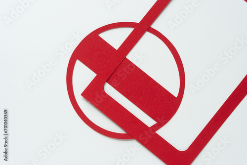 two machine-cut red paper shapes (rectangle frame and circle ring with bar) on blank paper