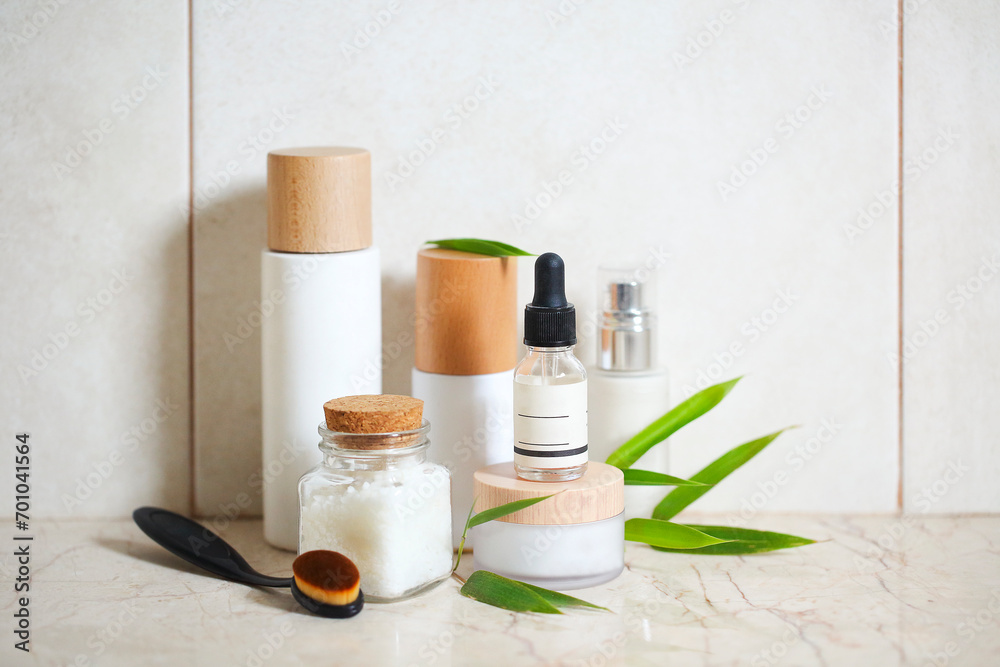 Face cream, serum, lotion, moisturizer and sea salt  among bamboo leaves
