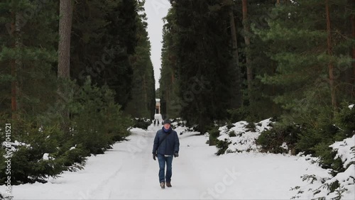 Stockholm, Sweden A man walks in the Woodland Cemetery, Skogskyrkogarden, a Unesco World Heritage Site, in winter.  photo