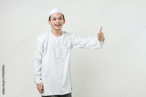 Asian Muslim give thumb up gesture on isolated background. People religious Islamic lifestyle concept