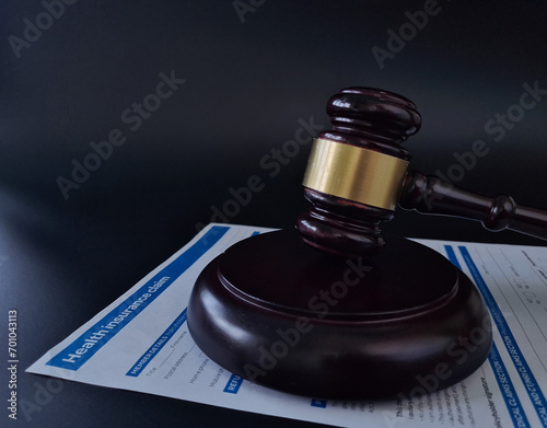 Closeup of wooden hammer in form of insurance claim on wooden table photo