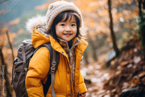Child Hiking in Autumn Forest with Yellow Jacket and Backpack  
