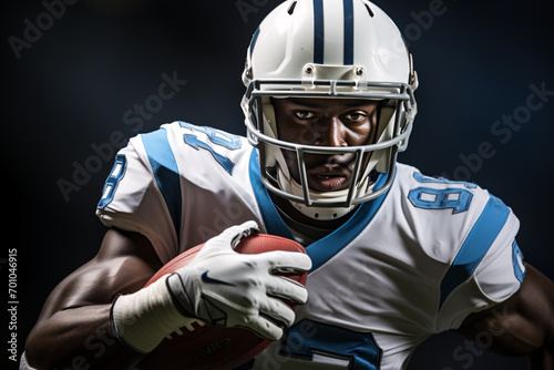 Focused football player in blue jersey holding ball