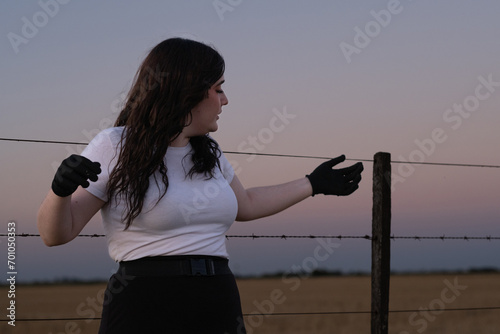 Chica bonita posando despreocupada al aire libre durante el atardecer photo