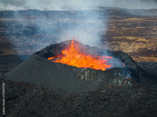 Stunning shot of dramatic moment of a volcano eruption, summit crater with boiling magma, aerial directly above view. Powerful force of nature concept.