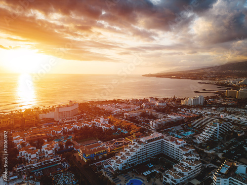 sunset at ocean shore with hotels and villas of Tenerife, Canary island, aerial photo