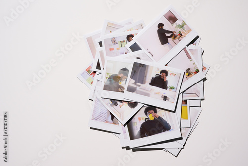 heap of Polaroid photos depicting various candid moments of an entrepreneur's life at work, from deep in thought to enjoying a simple coffee break, against the backdrop of a vibrant and energetic work photo