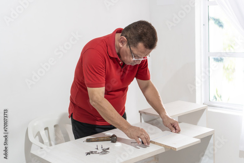 Senior Man Assembling White Desk