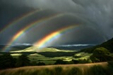 rainbow in the mountains, Double rainbow on a gray sky after rain. A rare atmospheric phenomenon after a storm. Beautiful hilly landscape with a real rainbow after rain on a summer day. stock photo