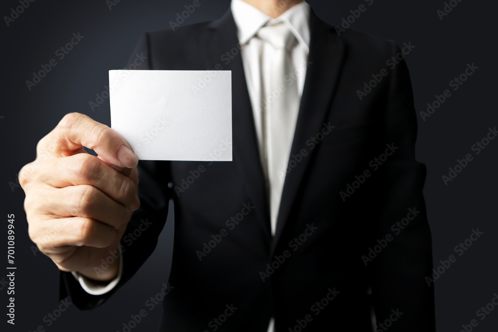 Communication in business circles. ,Announcement of news. ,Businessman holding a white paper note Communication in business circles. ,Announcement of news. ,Businessman holding a white paper note