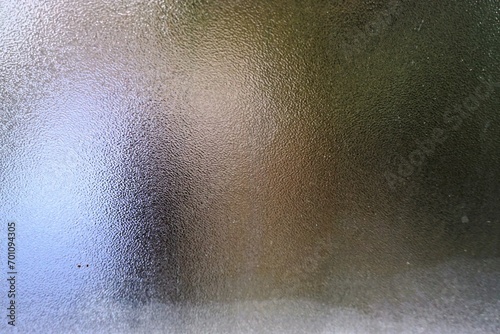 Beschlagene Fensterscheibe mit Muster und Rand mit Frost als Hintergrund